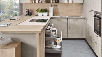 Einbauküche Nobilia® aus Holz in Holzfarben Hell nobilia® Einbauküche Riva mit JUNKER Elektrogeräten und Esstheke Beton Sand & Eiche Montreal - Stellfläche ca. 304 x 319 cm